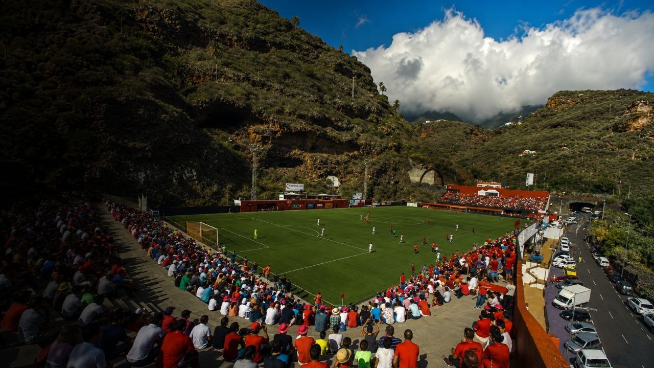 Vista panorámica del Estadio Silvestre Carrillo, con el partido y la afición rodeados por el paisaje de La Palma
